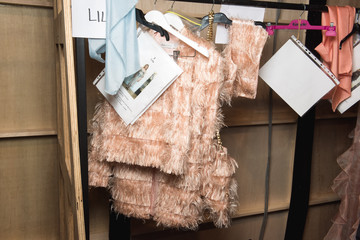 Máster en Dirección de Empresas Burro de ropa con varias prendas en lo que se intuye como un backstage